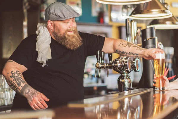 Радостный бармен склоняется на рабочем месте и смеется — стоковое фото