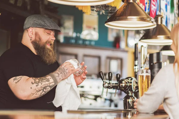 Homem tatuado concentrando-se no trabalho enquanto estava de pé no pub — Fotografia de Stock