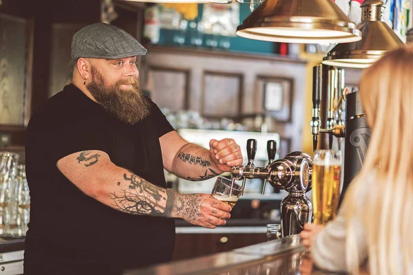 Vidám csapos töltés bögre hideg világos sör a pub — Stock Fotó