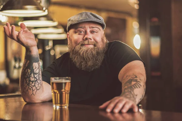 Sonriente barbudo macho bebiendo cerveza en el pub — Foto de Stock