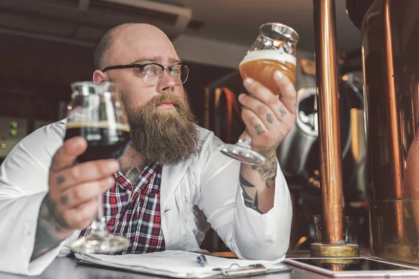 Сконцентрированный бородатый мужчина, стоящий в пивоварне — стоковое фото