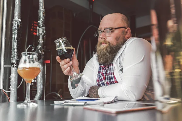 Chico seguro que trabaja con concentración mientras está parado en la cervecería — Foto de Stock