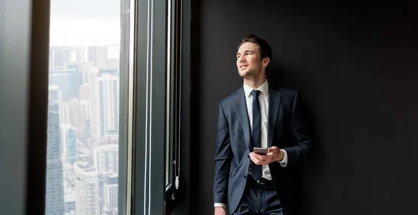 Empresário agradável alegre está de pé no escritório — Fotografia de Stock