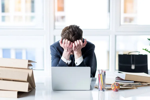 Jovem funcionário está cansado de trabalhar no laptop — Fotografia de Stock