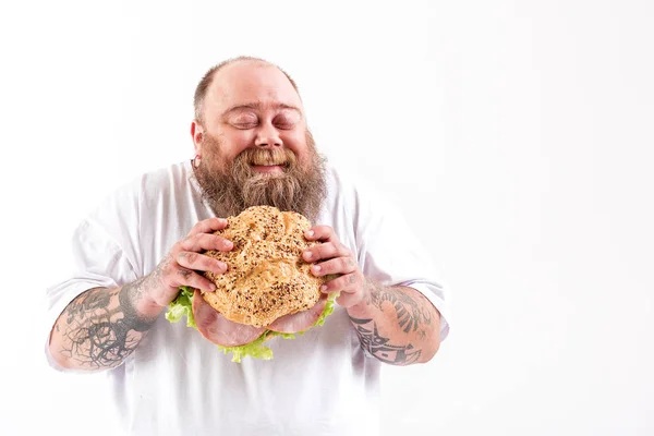 Gioioso spessa ragazzo mangiare grande panino con carne — Foto Stock