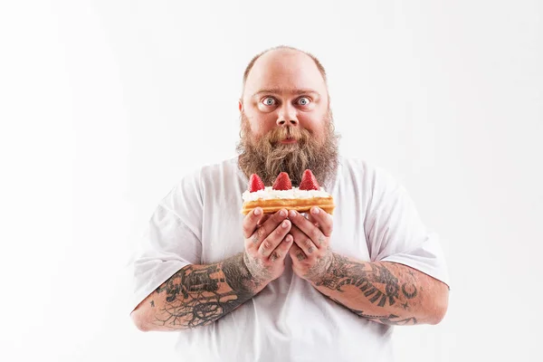 Homem gordo excitado segurando comida doce — Fotografia de Stock