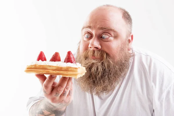 Hladový silný chlap zíral na sladká jídla — Stock fotografie
