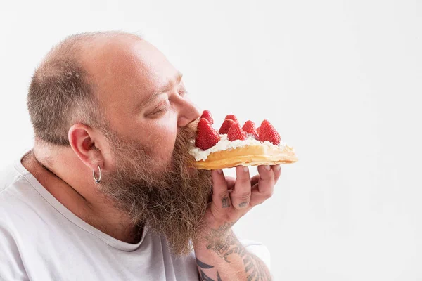 Rilassato grasso maschile mangiare torta gustosa — Foto Stock