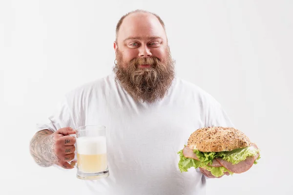 Kendine güvenen erkek fatso burger ile alkol içecek holding — Stok fotoğraf