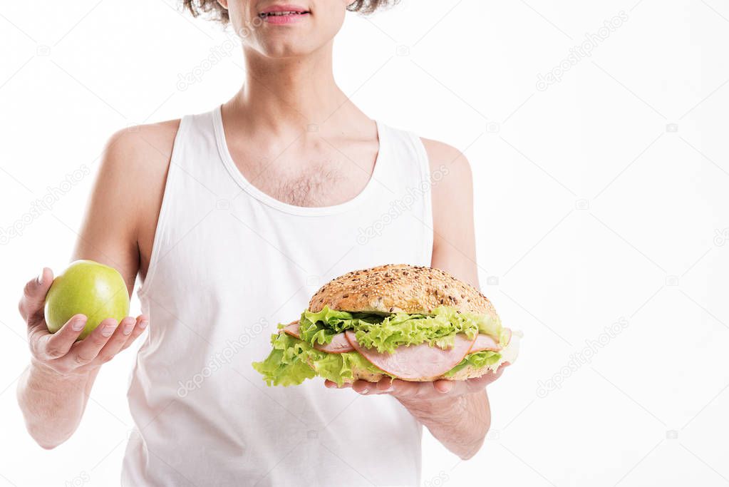 Thin guy choosing between fruit and sandwich