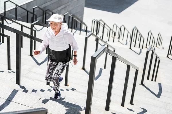 Веселая пожилая женщина практикует кардио-упражнения на открытом воздухе — стоковое фото