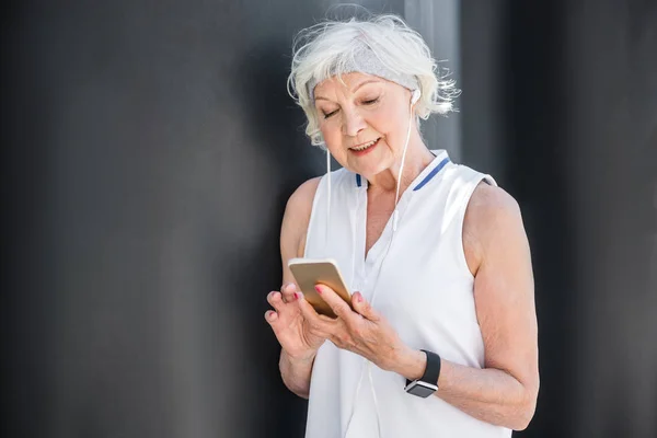 Feliz anciana utilizando el teléfono móvil para la comunicación al aire libre — Foto de Stock