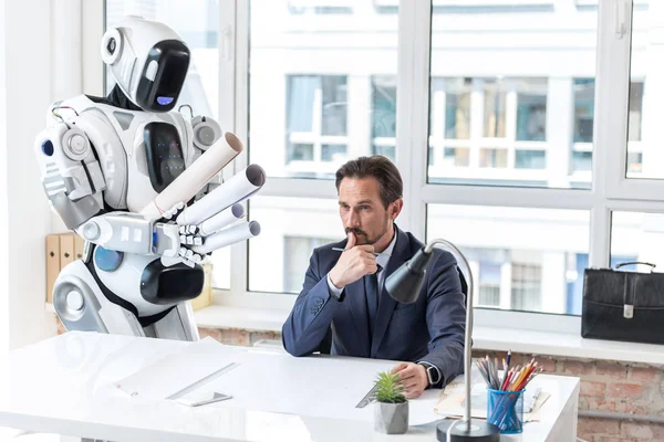 Крупный бизнесмен в костюме работает с роботом — стоковое фото