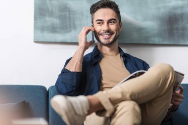 Mutlu genç sakallı adam kanepede kapalı keyfi yerinde