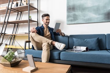 Neşeli genç adam onun aprtment rahatlatıcı