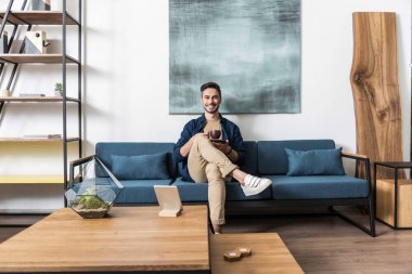 Onun sıcak içecek evde zevk neşeli yakışıklı adam