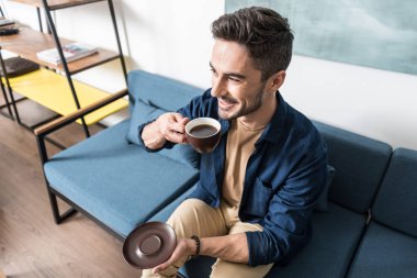 Neşeli genç adam onun sıcak içecek evde zevk