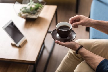 Genç adam evde sıcak içecek yudumlarken rahatlatıcı