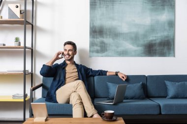 Neşeli çekici adam modern teknolojiler ile evden çalışma