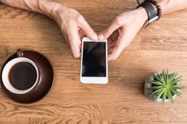 Genç adam cep telefonuyla kahve-molası sırasında kapalı