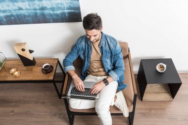 Mutlu genç adam onun odasında bilgisayarda çalışma