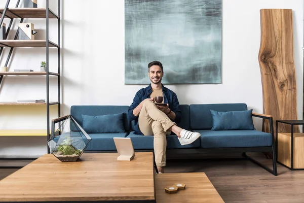 Onun sıcak içecek evde zevk neşeli yakışıklı adam