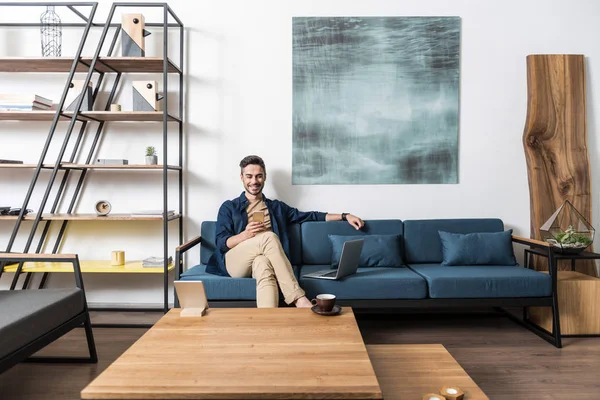 Neşeli genç adam onun odasında cep telefonu üzerinden iletişim