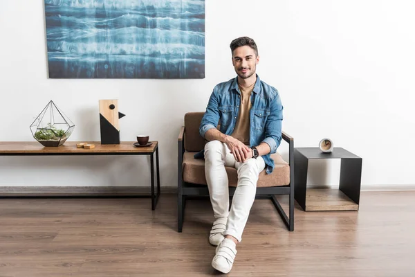 Alegre chico joven relajándose en la sala de estar — Foto de Stock