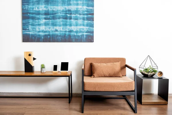 Tabulka s pohodlném křesle a jasný obraz v lesklé bytě — Stock fotografie