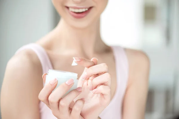 Youthful girl using day cream with joy — Stock Photo, Image