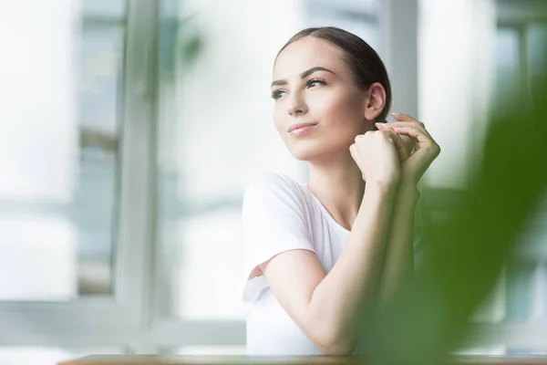 Menina atraente alegre descansando depois de aplicar cosméticos decorativos faciais — Fotografia de Stock