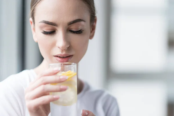 Calm beautiful girl with perfect make-up drinking fresh lemon water — Stock Photo, Image