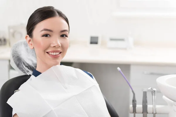 Wesoła dziewczyna, sytuując na siedzeniu w stomatologii — Zdjęcie stockowe