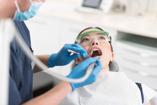 Mujer seria haciendo tratamiento en odontología — Foto de Stock