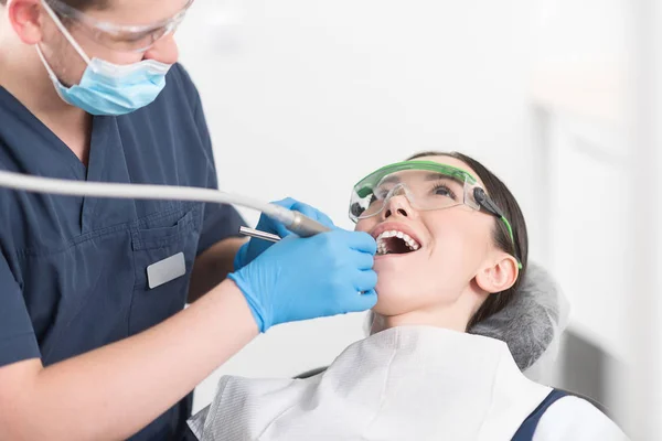 Doctor perforando dientes de chica alegre —  Fotos de Stock