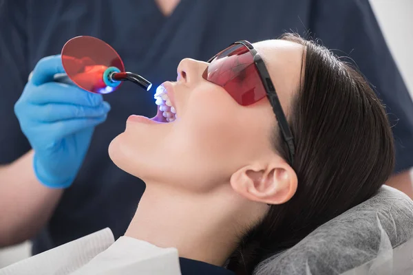 Dentista mirando a través de la boca de la mujer tranquila —  Fotos de Stock
