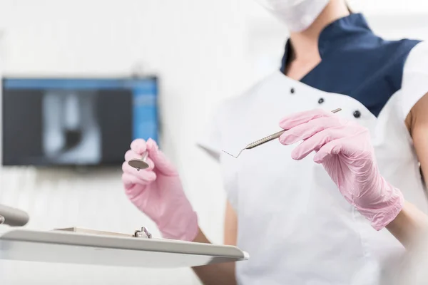 Odontologista braços segurando equipamentos para curar o paciente — Fotografia de Stock