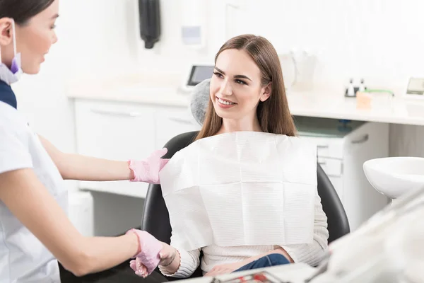 Lachende vrouw groet met tandheelkundige chirurg — Stockfoto