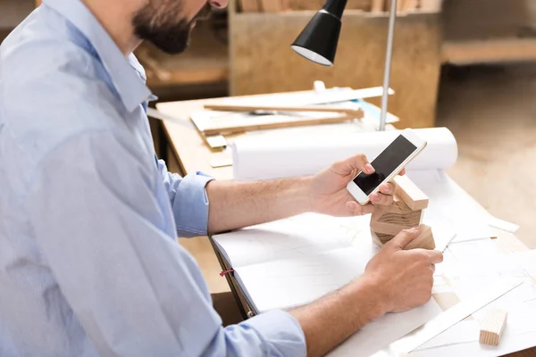 Koncentrované truhlář je odesílání zpráv pomocí smartphonu — Stock fotografie