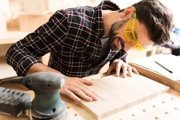 Vrolijke timmerman is het controleren van zijn werk — Stockfoto