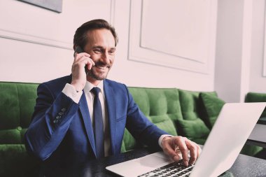 İletişim için Smartphone kullanarak emin iş adamı