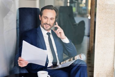 Cep telefonu üzerinde konuşurken kendine güvenen erkek Yöneticisi
