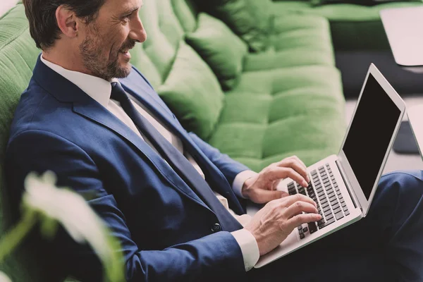 Happy businessman working on portable computer