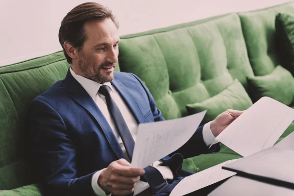 Happy man in suit reading papers — Stock Photo, Image