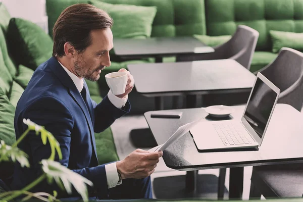 Busy man checking papers during coffee break — Stock Photo, Image