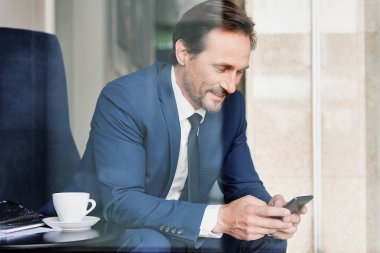 Cep telefonunuzun mesajlaşma takım elbiseli olumlu adam