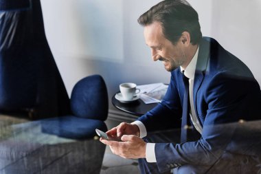 Başarılı erkek yönetici tipik haber üstünde hareket eden telefon