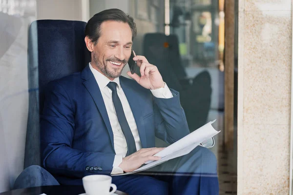 Smartphone Cafe tarafından konuşma neşeli üst düzey iş adamı