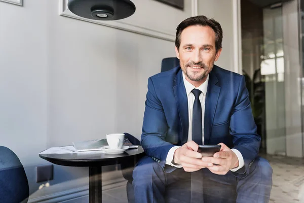 Hombre de negocios alegre con teléfono inteligente en la cafetería — Foto de Stock