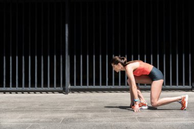 Başlama pozisyonu ayakta ciddi kadın runner